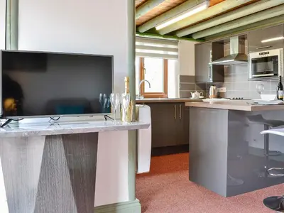 a kitchen with a large flat screen tv on a counter at Darci's Lodge - Uk1297 in Threlkeld