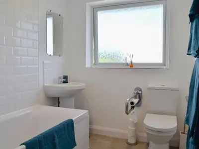 a bathroom with a sink and a toilet and a window at Rotherwood in Portinscale