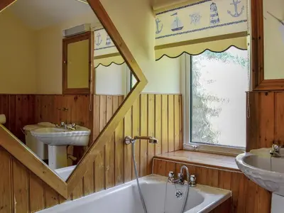 a bathroom with a tub and a sink and a mirror at Brackendale Cottage - Uk1335 in Threlkeld