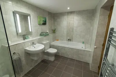 a bathroom with a sink and a toilet and a bath tub at Lords Seat Bed & Breakfast in Keswick