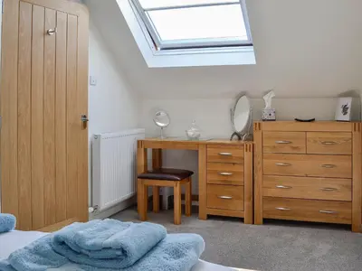 a bedroom with a bed and a desk and a skylight at Little Cottage in Wigtown