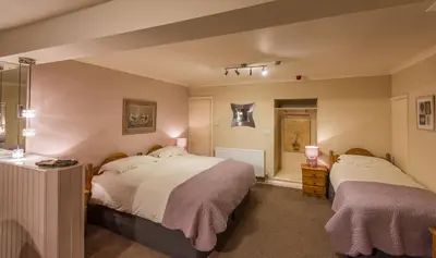 a bedroom with two beds and a window at The Devonian in Douglas