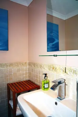 a bathroom with a sink with a soap bottle on it at The Devonian in Douglas