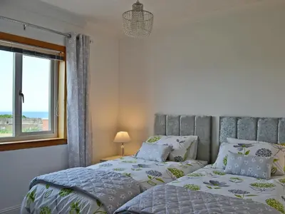 a bedroom with two beds and a window at Ingleside in Ballantrae