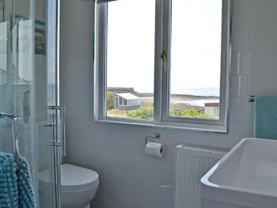 a bathroom with a toilet and a sink and a window at Ingleside in Ballantrae