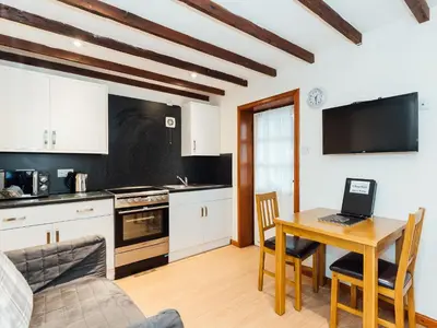 a kitchen with a table with a laptop on it at The Bothy - Uk5803 in Girthon