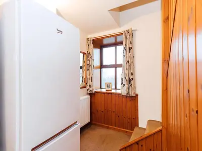 a kitchen with a window and a refrigerator at The Bothy - Uk5803 in Girthon