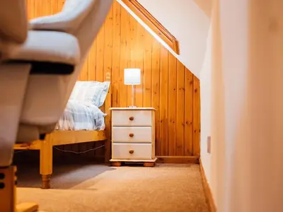 a bedroom with a bed and a table with a lamp at The Bothy - Uk5803 in Girthon