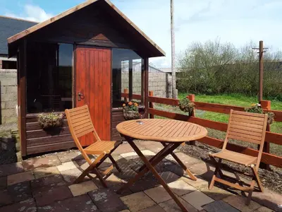 a table and two chairs in front of a gazebo at The Bothy - Uk5803 in Girthon