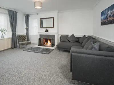 a living room with a couch and a fireplace at Callander's High Street in Gatehouse of Fleet