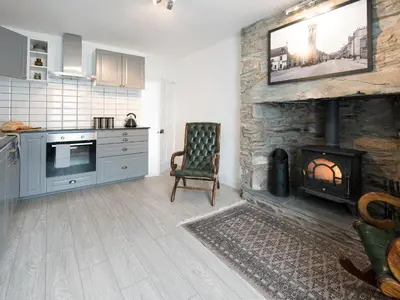 a kitchen with a fireplace with a tv on the wall at Callander's High Street in Gatehouse of Fleet