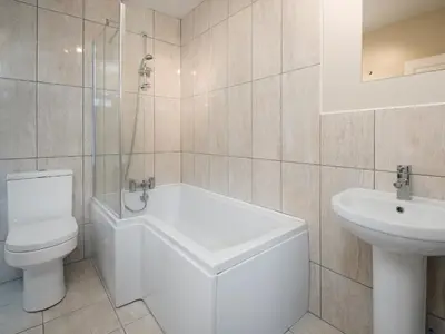 a white bathroom with a toilet and a sink at Callander's High Street in Gatehouse of Fleet