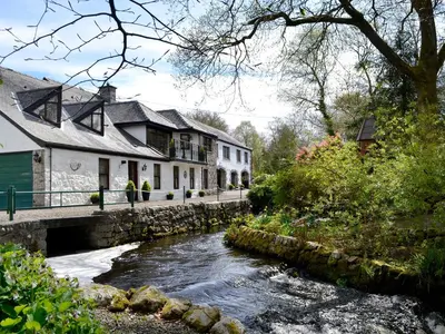 a river in front of houses and a bridge at Anvil in Dalbeattie