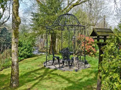 a park bench in the middle of a park at Waterwheel in Dalbeattie