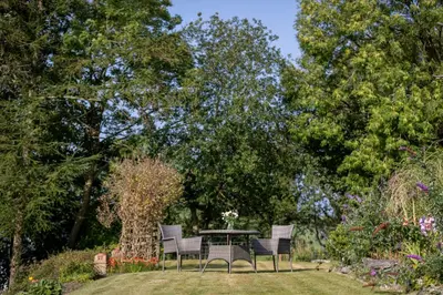 a table and chairs in a garden with trees at Craigmount in Wigtown