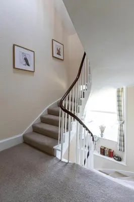 a winding staircase in a home with white walls at Craigmount in Wigtown