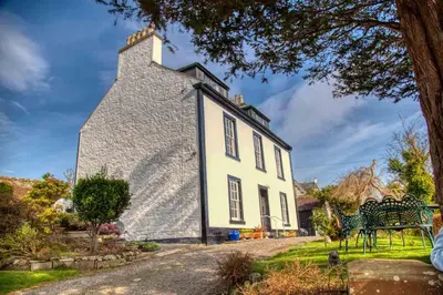 a large white house with a bench in front of it at Craigmount in Wigtown