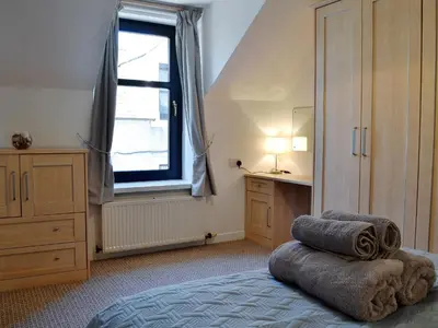 a bedroom with a bed and a window and a desk at Summerlea Cottage in Moffat
