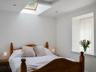 a bedroom with a bed with white walls and a window at Kirroughtree Steading 1 - Uk5859 in Newton Stewart