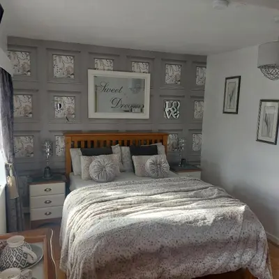 a bedroom with a large bed with a wooden headboard at Broadlea of Robgill Country Cottage bed and breakfast in Ecclefechan