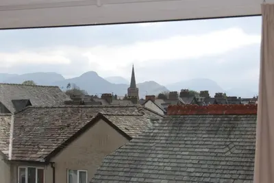 a view of roofs with a church in the background at Beckside Guest House Keswick in Keswick