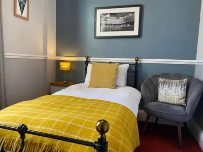 a bedroom with a bed and a chair at Goodwin House in Keswick