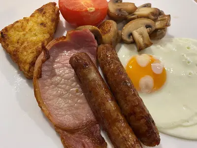 a plate of breakfast food with eggs sausage and mushrooms at Goodwin House in Keswick