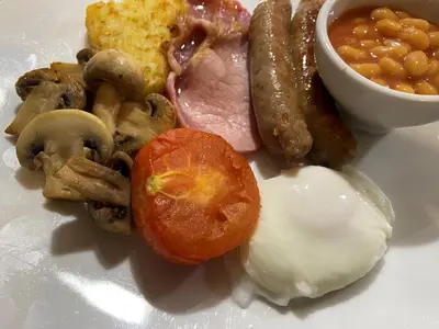 a plate of food with eggs sausage mushrooms and a tomato at Goodwin House in Keswick