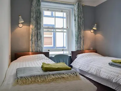 a bedroom with two beds and a window at Applegarth in Cockermouth