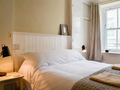a bedroom with a white bed and a window at Applegarth in Cockermouth