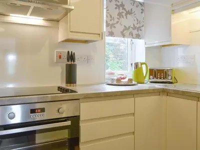a kitchen with white cabinets and a stove at Shepherds Bield - Uk1349 in Threlkeld