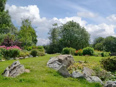 a garden with rocks in the grass and flowers at Low Cordorcan - Uk5891 in Bargrennan