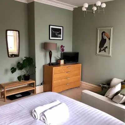 a bedroom with a bed and a tv and a couch at Salisbury Guest House in Keswick
