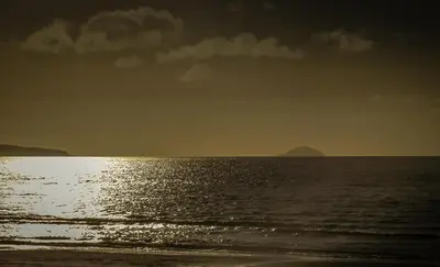 a view of the ocean with the sun reflecting on the water at Sea Breeze - Donnini Apartments in Ayr
