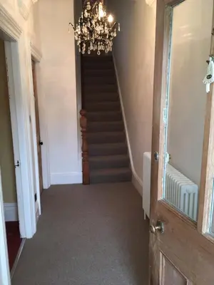 a hallway with a chandelier and a staircase at Raymonds in Douglas