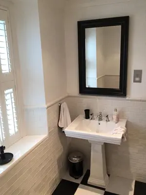 a bathroom with a sink and a mirror and a tub at Raymonds in Douglas