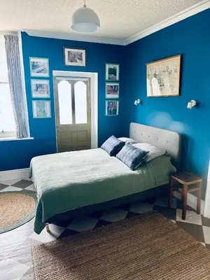 a bedroom with blue walls and a bed at Fitz House in Keswick