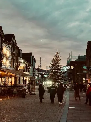 a group of people walking down a street with a christmas tree at Fitz House in Keswick