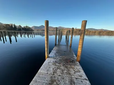 a wooden dock in the water on a lake at Fitz House in Keswick