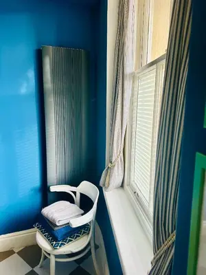 a blue room with a chair next to a window at Fitz House in Keswick