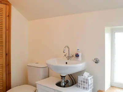 a bathroom with a sink and a toilet at Farm Cottage in Cleator
