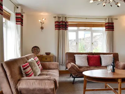 a living room with two couches and a table at Farm Cottage in Cleator