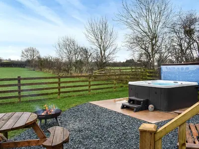 a backyard with a hot tub and a grill at Greengill Farm Shepherds Hut- Ukc3632 in Gilcrux