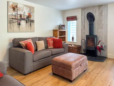 a living room with a couch and a wood stove at Townend Cottage in Aikton