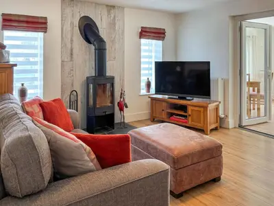 a living room with a couch and a fireplace at Townend Cottage in Aikton
