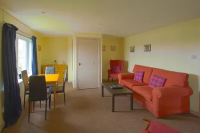 a living room with a couch and a table and chairs at Harbour Inn Appartments in Garlieston