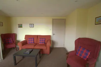 a living room with two chairs and a table at Harbour Inn Appartments in Garlieston