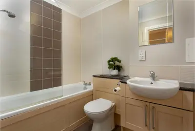 a bathroom with a toilet and a sink and a tub at Harris Retreat - Donnini Apartments in Ayr
