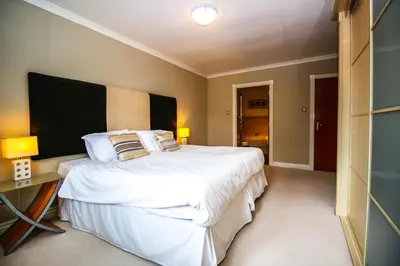 a bedroom with a large bed with white sheets and pillows at Turnberry Apartments in Turnberry