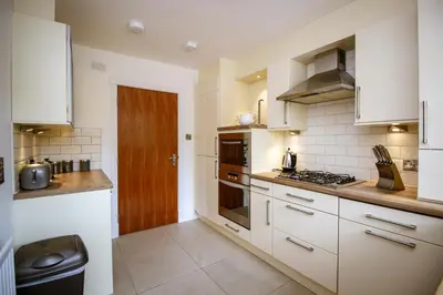 a kitchen with white cabinets and a stove top oven at Turnberry Apartments in Turnberry